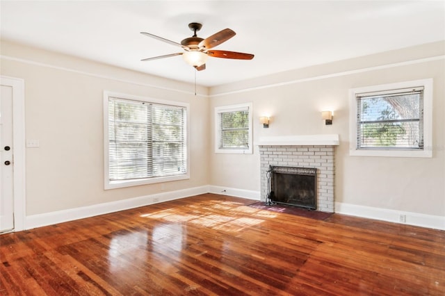 unfurnished living room with hardwood / wood-style floors, ceiling fan, a fireplace, and a wealth of natural light