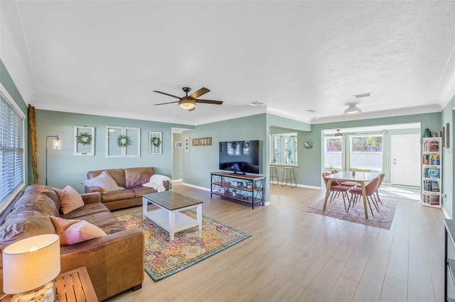 living room featuring light wood-type flooring, ceiling fan, and crown molding