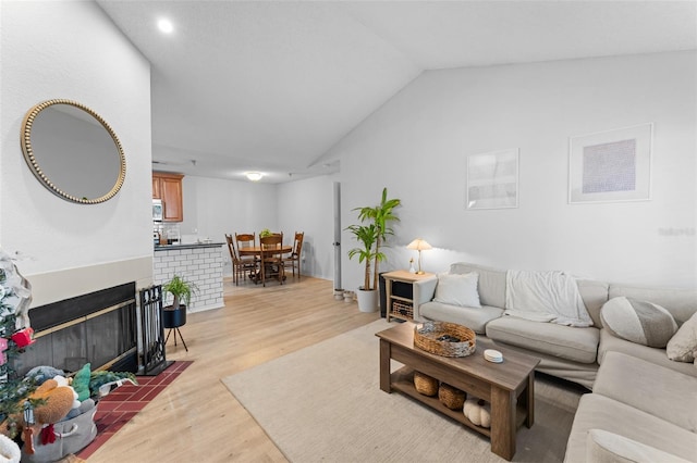 living room featuring vaulted ceiling and light hardwood / wood-style flooring