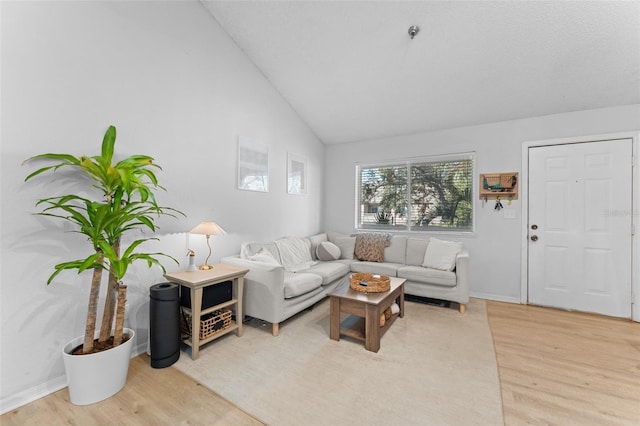 living room featuring light hardwood / wood-style flooring and high vaulted ceiling