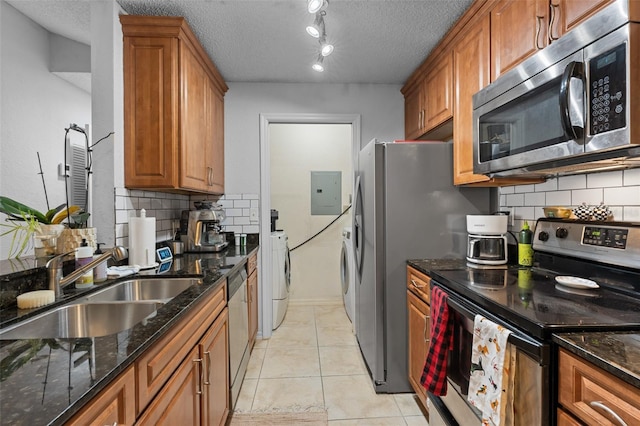 kitchen featuring appliances with stainless steel finishes, tasteful backsplash, a textured ceiling, sink, and light tile patterned floors