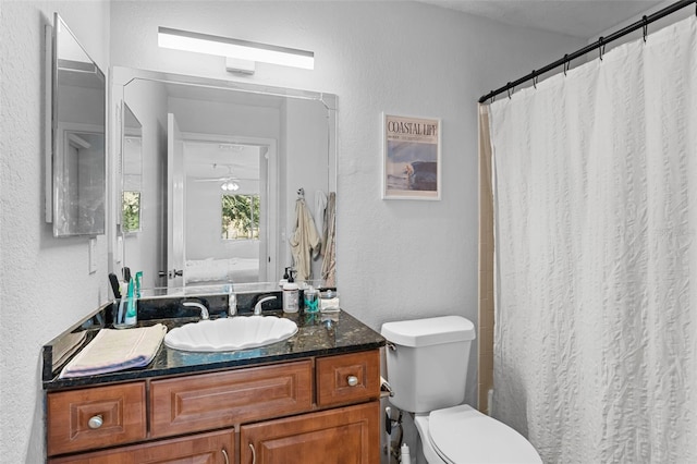 bathroom featuring a shower with shower curtain, vanity, and toilet