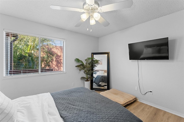 bedroom featuring ceiling fan, a textured ceiling, and hardwood / wood-style flooring