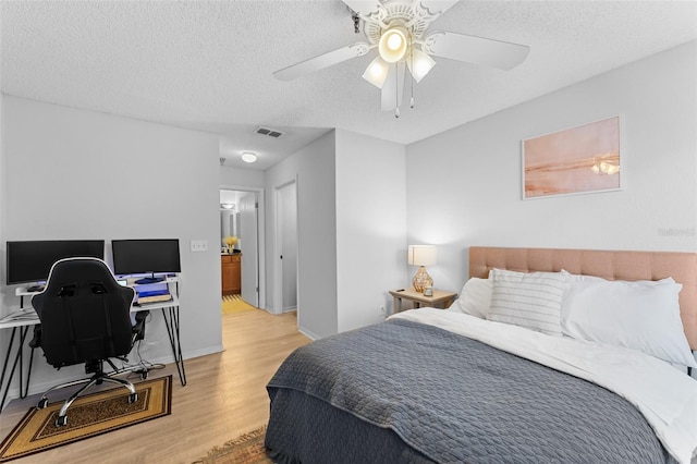 bedroom featuring a textured ceiling, light hardwood / wood-style flooring, and ceiling fan