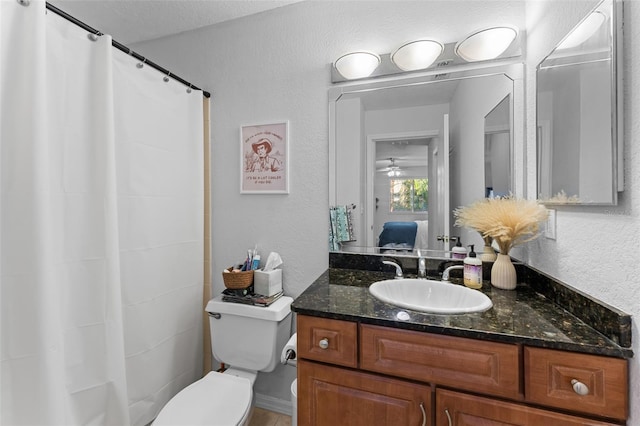 bathroom featuring vanity, ceiling fan, and toilet