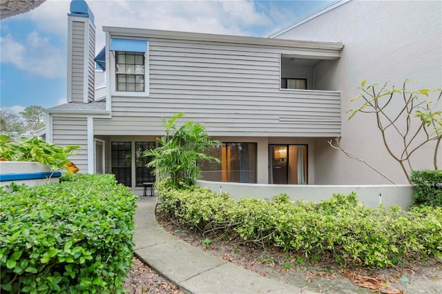 exterior space with a chimney and stucco siding