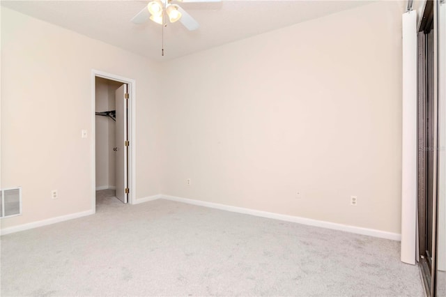 unfurnished bedroom featuring visible vents, light carpet, baseboards, and a spacious closet