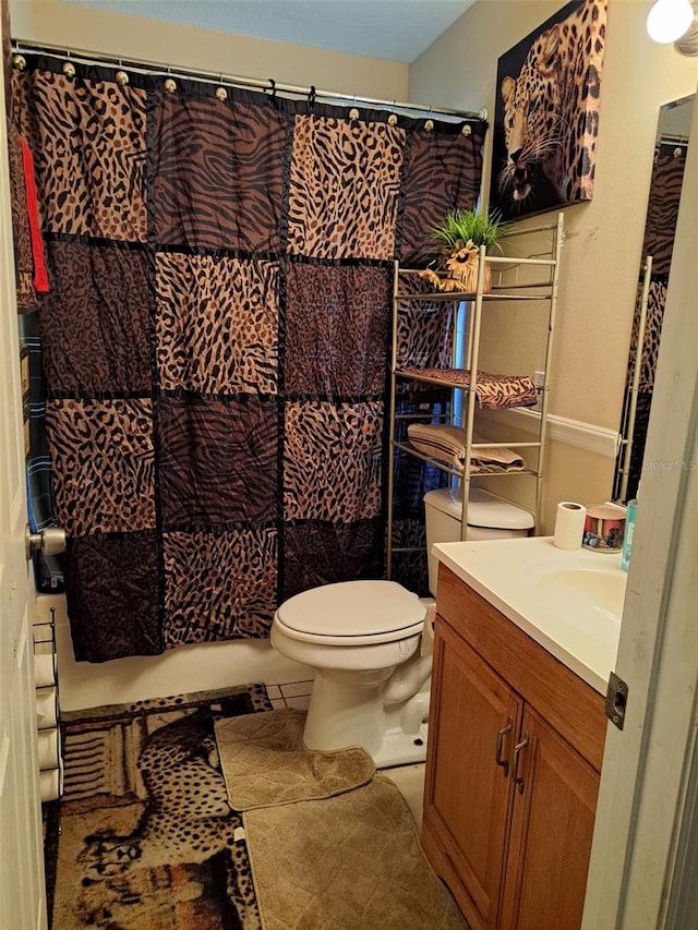 bathroom featuring tile patterned flooring, vanity, and toilet