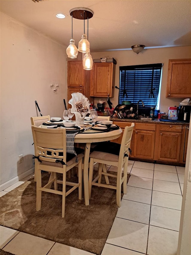 dining space featuring sink and light tile patterned floors