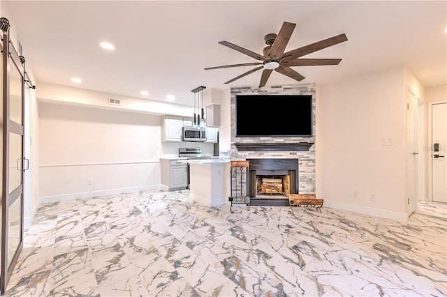 unfurnished living room featuring a stone fireplace and ceiling fan