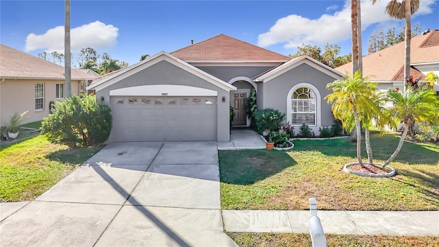 single story home with a garage and a front lawn