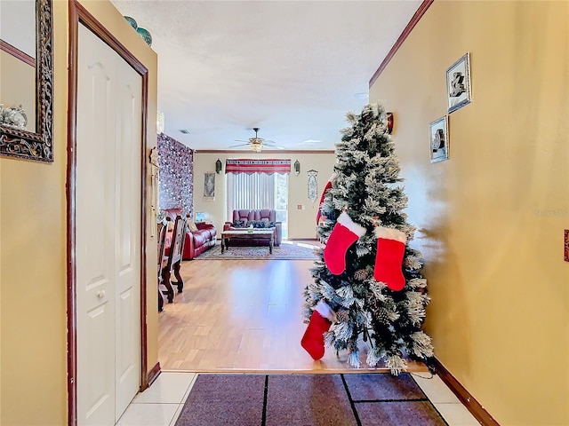 hall featuring light wood-type flooring and crown molding