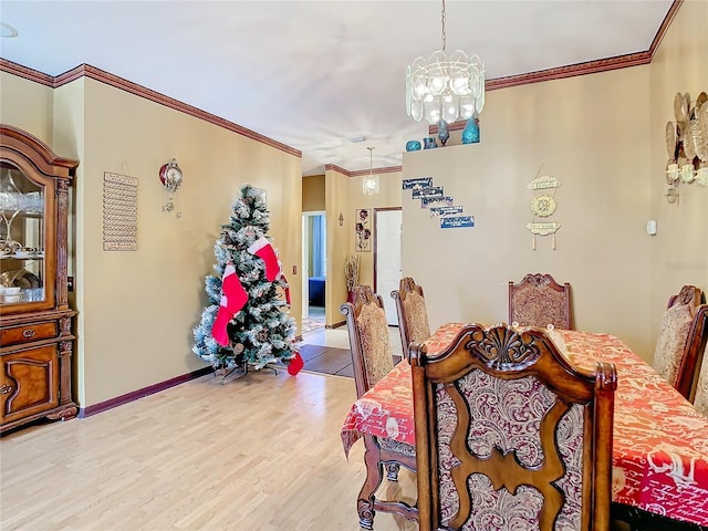 dining area with a notable chandelier, light hardwood / wood-style floors, and ornamental molding