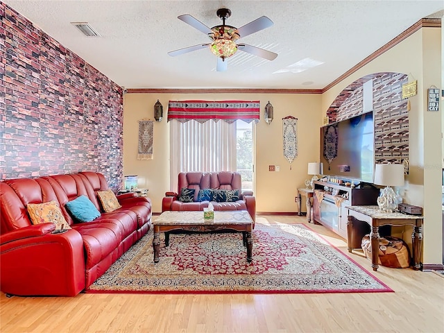 living room featuring ceiling fan, crown molding, a textured ceiling, and hardwood / wood-style flooring