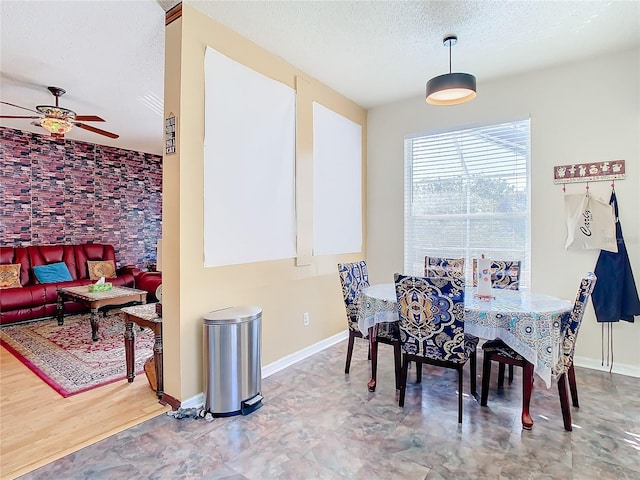 dining area with ceiling fan and a textured ceiling