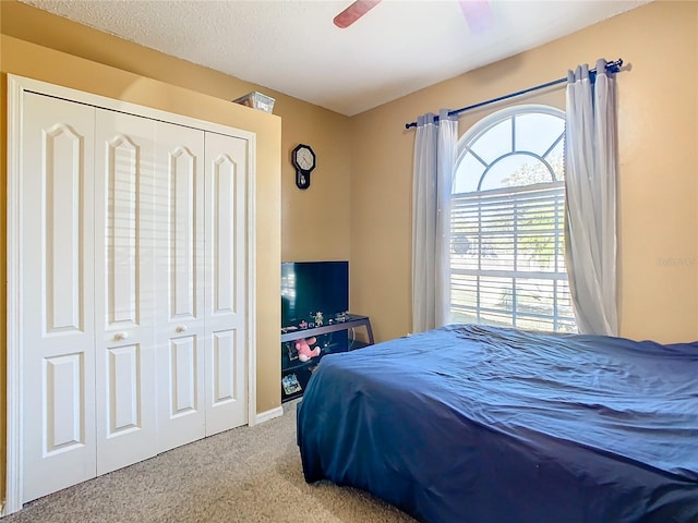 carpeted bedroom featuring a closet and ceiling fan