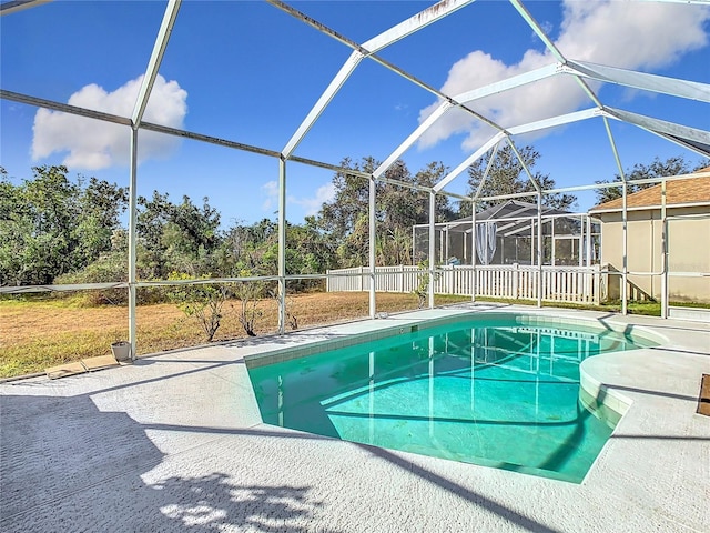 view of pool featuring glass enclosure and a patio area