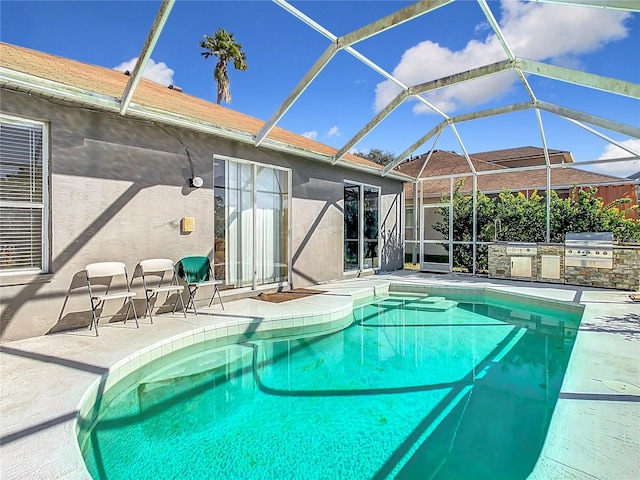 view of swimming pool featuring a lanai, a grill, exterior kitchen, and a patio