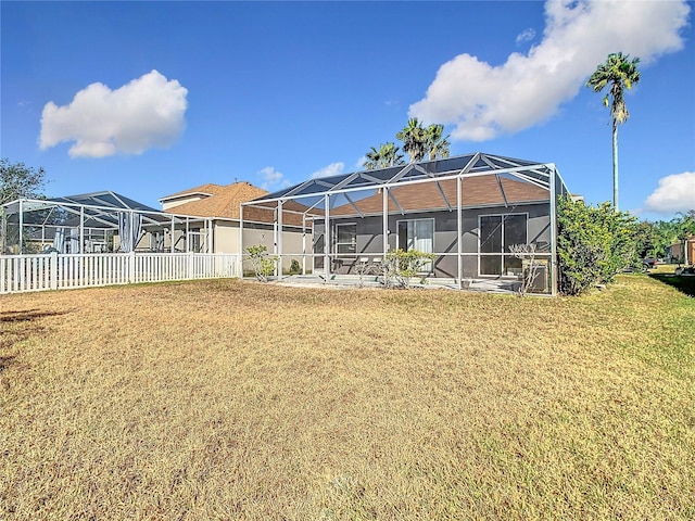 rear view of house with a lanai and a yard