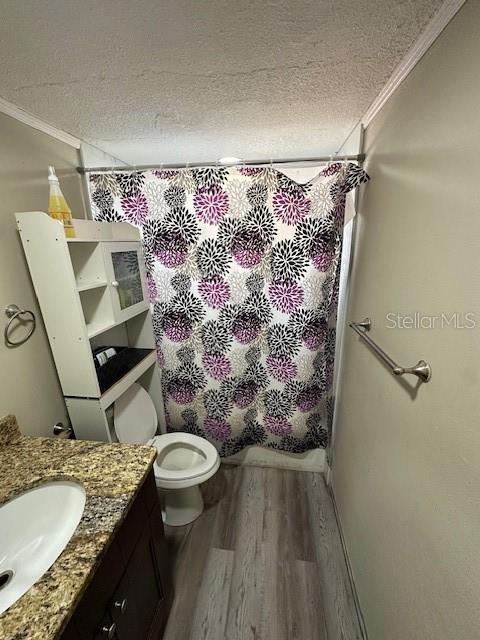 full bathroom with shower / bathtub combination with curtain, crown molding, a textured ceiling, and hardwood / wood-style floors