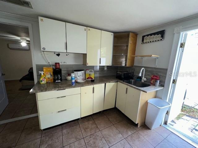 kitchen with sink, dark tile patterned flooring, and white cabinets