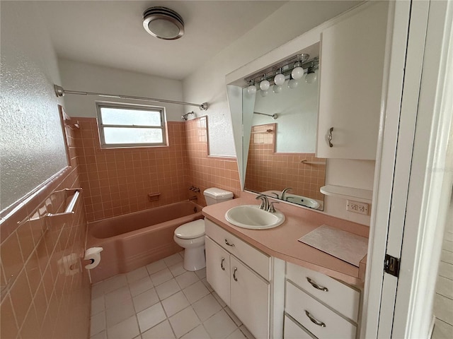 full bathroom featuring tiled shower / bath, tile patterned flooring, vanity, tile walls, and toilet