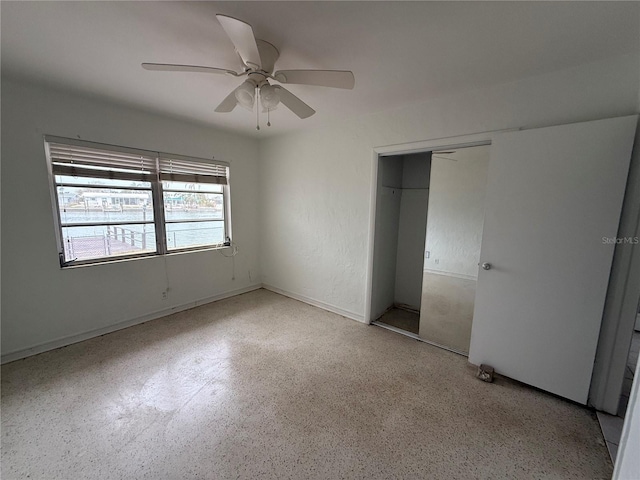 unfurnished bedroom with ceiling fan and a closet