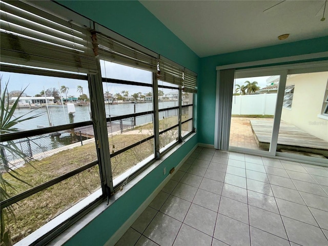 unfurnished sunroom featuring a water view and lofted ceiling