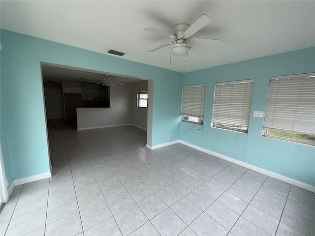 tiled empty room featuring ceiling fan