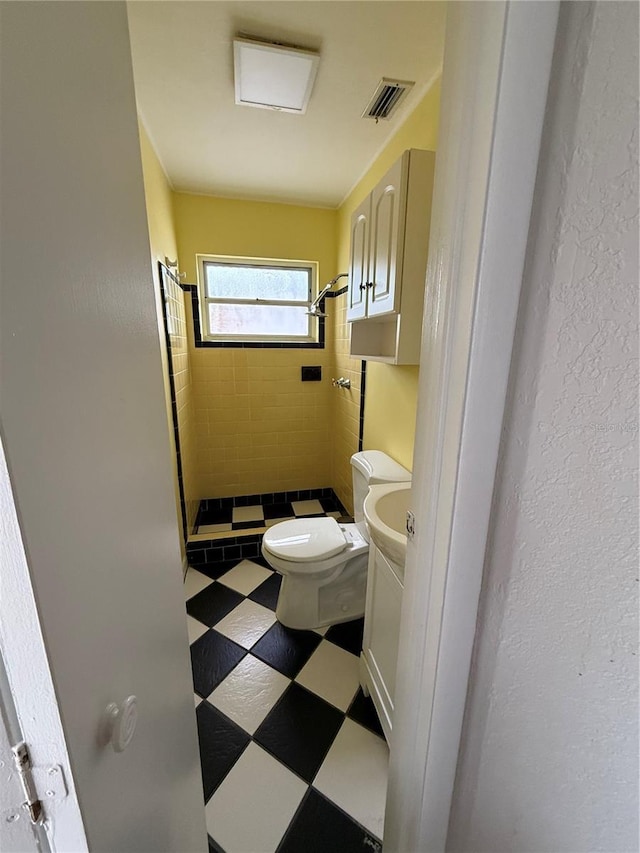 bathroom with toilet and a tile shower