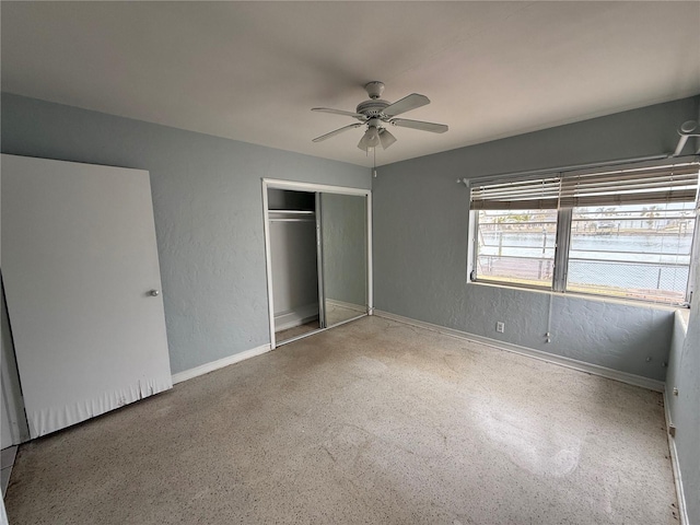 unfurnished bedroom with ceiling fan and a closet