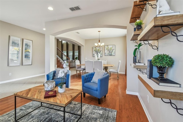 living room featuring an inviting chandelier and light hardwood / wood-style flooring