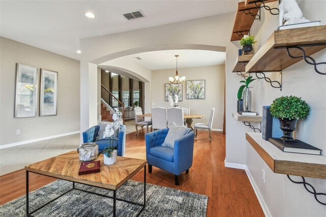 2212 Valterra Vista Way, Valrico, FL 33594 - living area with arched walkways, recessed lighting, stairs, light wood finished floors, and a chandelier