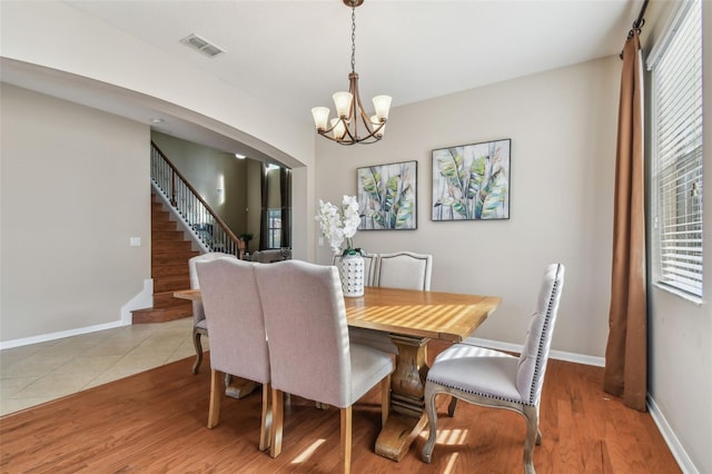 dining space with light hardwood / wood-style floors and a chandelier