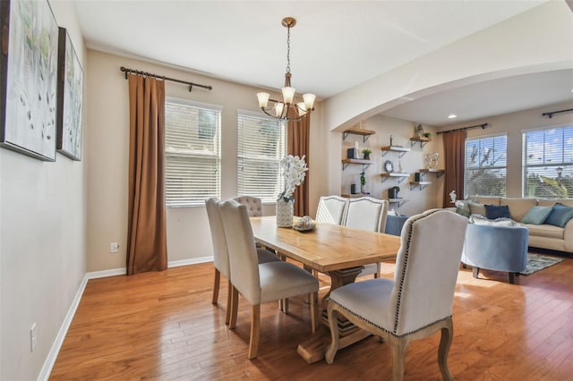 dining space featuring light hardwood / wood-style floors and an inviting chandelier