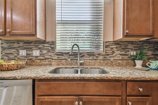 kitchen with backsplash, dishwasher, light stone countertops, and sink