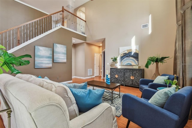 living room with a high ceiling and light hardwood / wood-style flooring