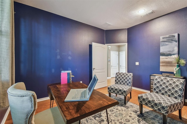 office area with wood-type flooring and a textured ceiling