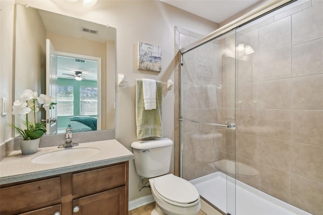 bathroom with ceiling fan, toilet, vanity, and walk in shower