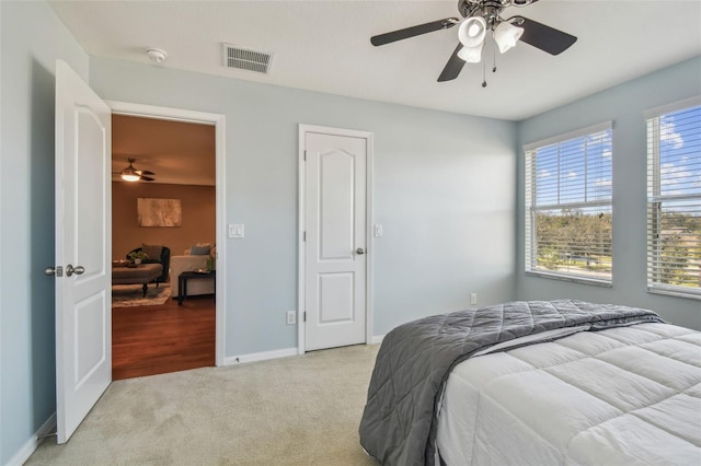 carpeted bedroom featuring multiple windows and ceiling fan