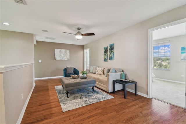 living room featuring dark hardwood / wood-style flooring and ceiling fan