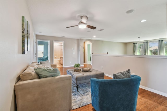 living room featuring ceiling fan, plenty of natural light, and light hardwood / wood-style flooring