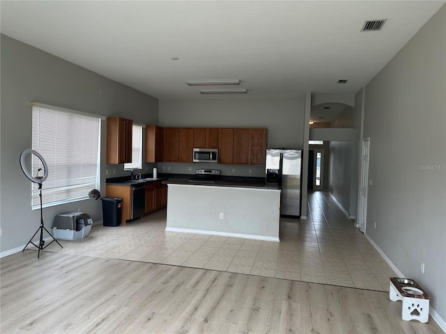 kitchen featuring a kitchen island, light wood-type flooring, and appliances with stainless steel finishes