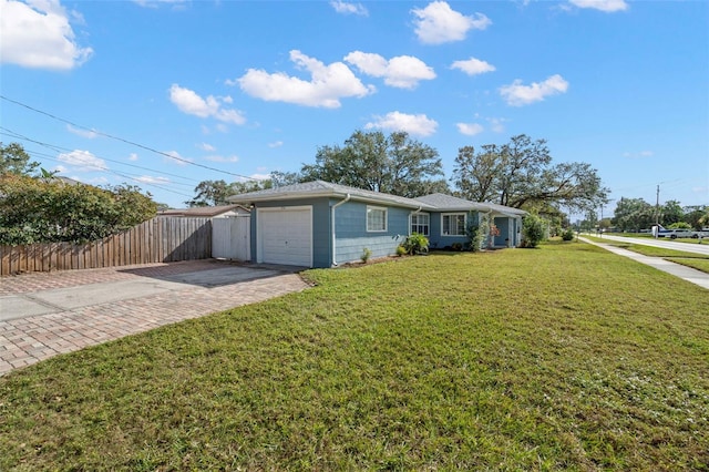 ranch-style home with a garage and a front lawn