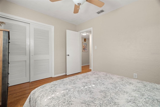 bedroom with hardwood / wood-style flooring, ceiling fan, and a closet