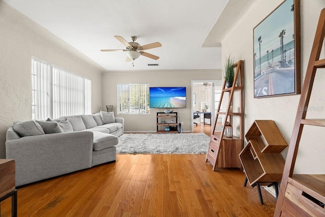 living room with wood-type flooring and ceiling fan