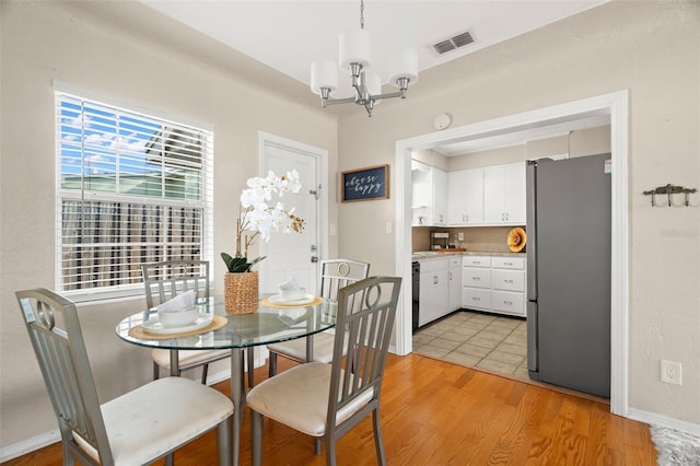 dining space featuring a notable chandelier and light hardwood / wood-style floors