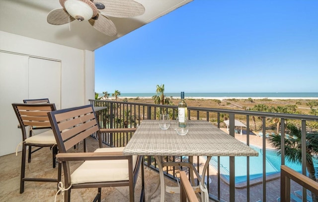 balcony with ceiling fan and a water view