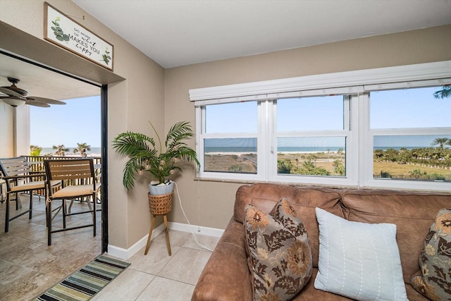 sitting room with a water view, ceiling fan, and light tile patterned flooring