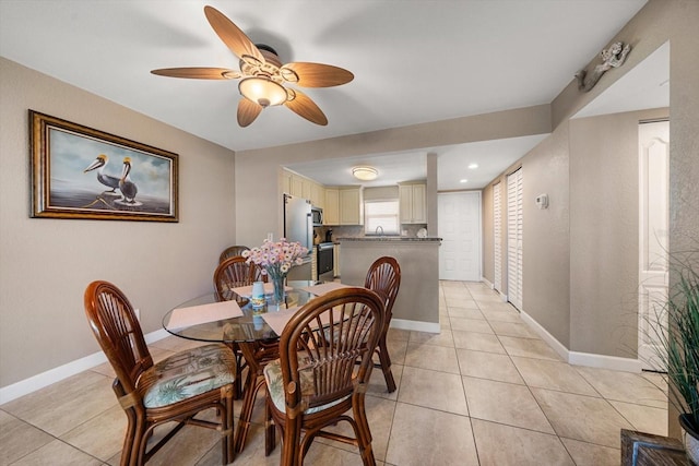 tiled dining room with ceiling fan and sink